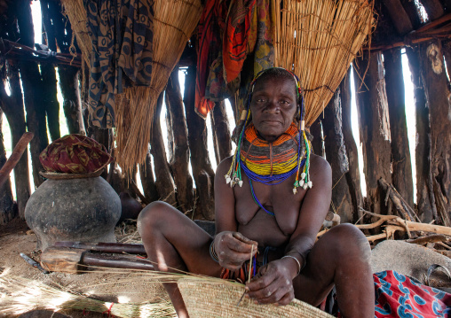 Mumuhuila tribe woman cooking inside her hut, Huila Province, Chibia, Angola