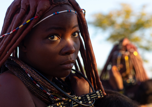 Himba tribe woman with a ray of light on her face, Cunene Province, Oncocua, Angola