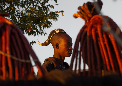 Himba tribe single man in front of married women, Cunene Province, Oncocua, Angola