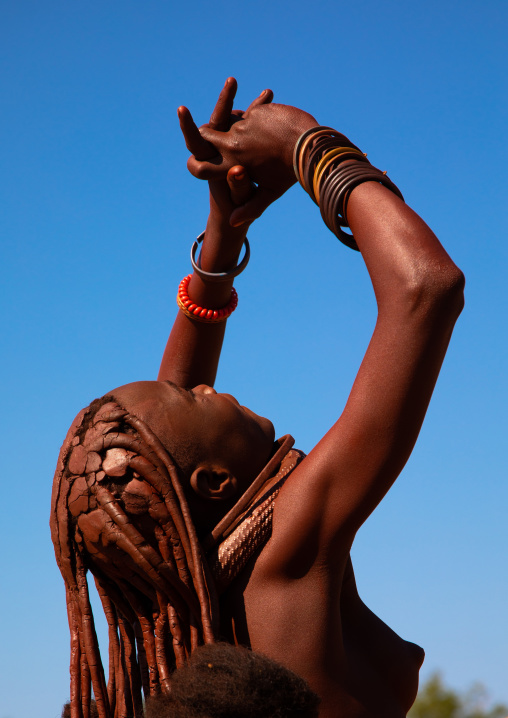 Batwa tribe woman looking up in the sky, Cunene Province, Oncocua, Angola