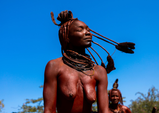 Batwa tribe woman dancing and playing with her dreadlocks, Cunene Province, Oncocua, Angola