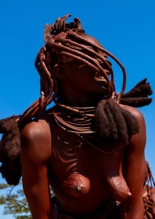 Batwa tribe woman dancing and playing with her dreadlocks, Cunene Province, Oncocua, Angola