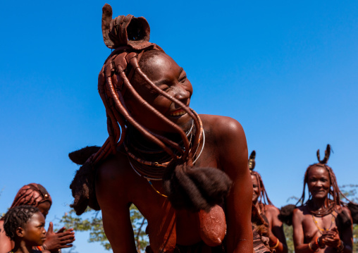 Batwa tribe woman dancing and playing with her dreadlocks, Cunene Province, Oncocua, Angola