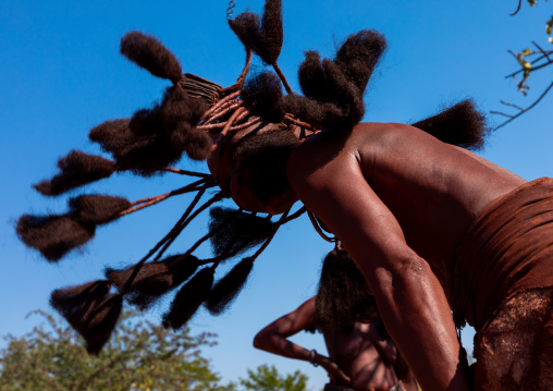 Batwa tribe woman dancing and playing with her dreadlocks, Cunene Province, Oncocua, Angola