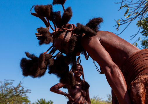 Batwa tribe woman dancing and playing with her dreadlocks, Cunene Province, Oncocua, Angola