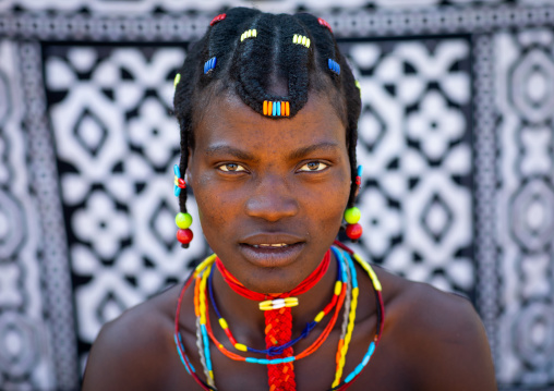 Portrait of a mudimba tribe woman in front of a printed cloth, Cunene Province, Cahama, Angola