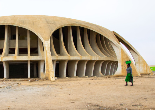 Angolan woman passing near cine estudio designed by botelho vasconcelos of atelier boper, Namibe Province, Namibe, Angola