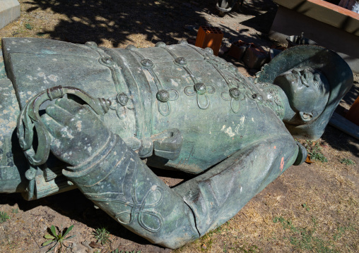 Old bronze portuguese statue laying down on the grass, Huila Province, Lubango, Angola