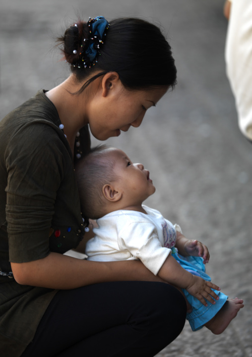 Mother Holding Her Baby To Make Pee In The Street, Jianshui, Yunnan Province, China