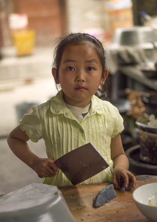 Chinese Kid With A Huge Knife At A Butcher Workshop, Lijiang, Yunnan Province, China