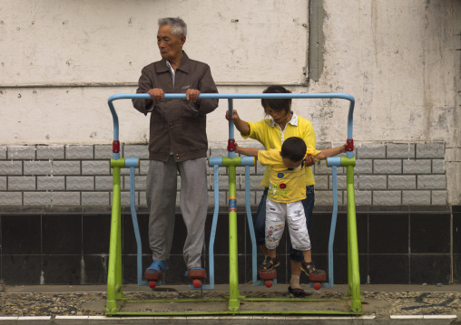 Old Man And Kids Making Gymnastic In The Street, Beijing, China