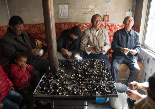 Volunteers cleaning butter lamps in Shachong monastery, Qinghai Province, Wayaotai, China