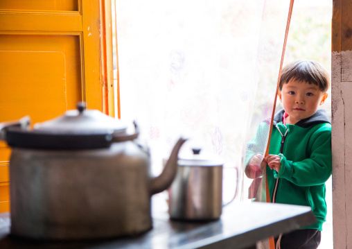 Salar ethnic minority boy at the entrance of his house, Qinghai province, Xunhua, China