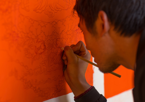 Tibetan artist painting a thangka at a workshop, Qinghai province, Wutun, China