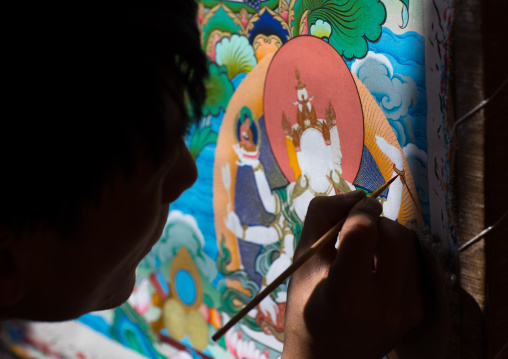 Tibetan artist painting a thangka at a workshop, Qinghai province, Wutun, China