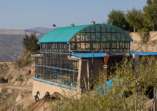 Traditonal tibetan wooden house covered with glass protection to keep the warmth in winter, Tongren County, Rebkong, China