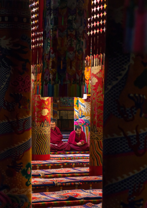 Monks praying and meditating inside Longwu monastery, Tongren County, Longwu, China