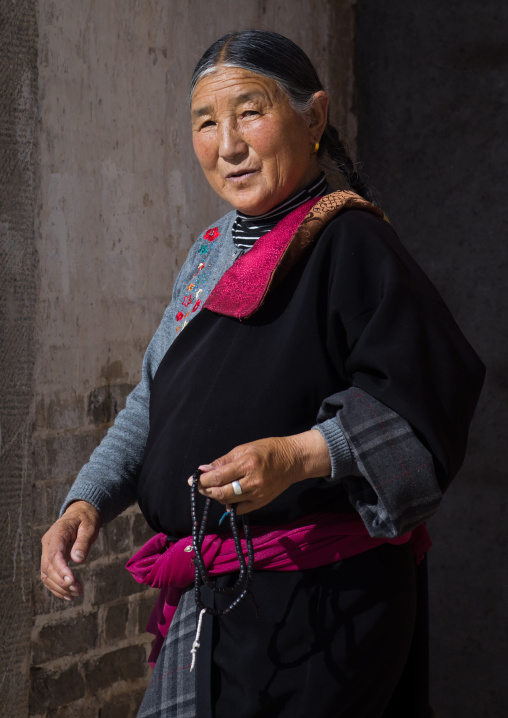 Pilgrim tibetan woman walking the kora around Rongwo monastery, Tongren County, Longwu, China