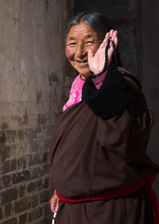 Pilgrim tibetan woman walking the kora around Rongwo monastery, Tongren County, Longwu, China