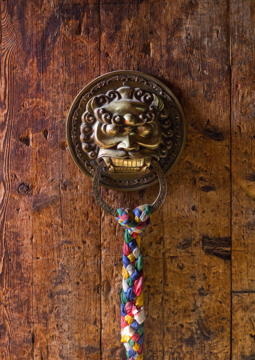 Ornate knockers on traditional buddhist door temple in Rongwo monastery, Tongren County, Longwu, China