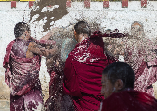 Tibetan monks enjoying a water fight after the yearly renovation of the Rongwo monastery, Tongren County, Longwu, China