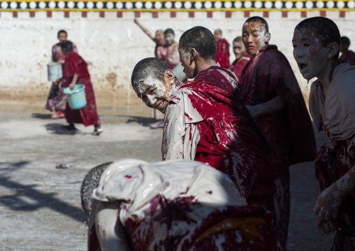 Tibetan monks enjoying a water fight after the yearly renovation of the Rongwo monastery, Tongren County, Longwu, China