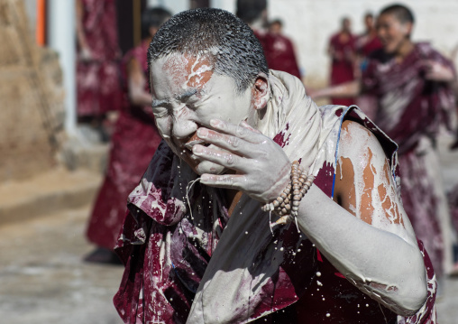 Tibetan monks enjoying a water fight after the yearly renovation of the Rongwo monastery, Tongren County, Longwu, China