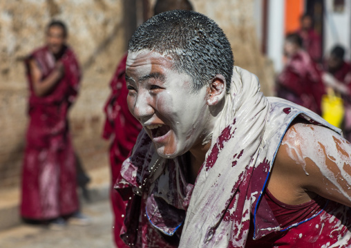 Tibetan monks enjoying a water fight after the yearly renovation of the Rongwo monastery, Tongren County, Longwu, China