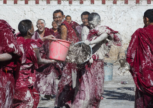 Tibetan monks enjoying a water fight after the yearly renovation of the Rongwo monastery, Tongren County, Longwu, China