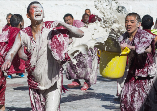 Tibetan monks enjoying a water fight after the yearly renovation of the Rongwo monastery, Tongren County, Longwu, China