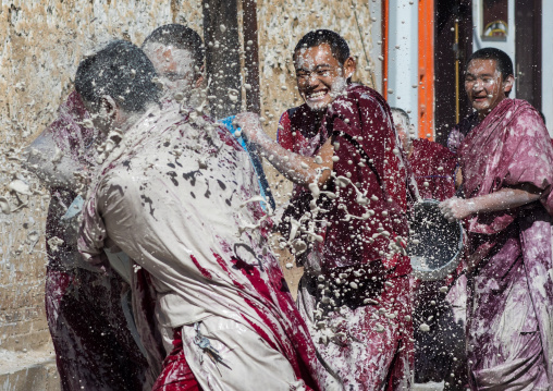 Tibetan monks enjoying a water fight after the yearly renovation of the Rongwo monastery, Tongren County, Longwu, China