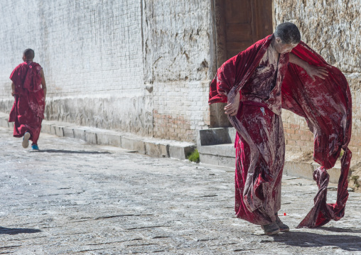 Tibetan monks enjoying a water fight after the yearly renovation of the Rongwo monastery, Tongren County, Longwu, China