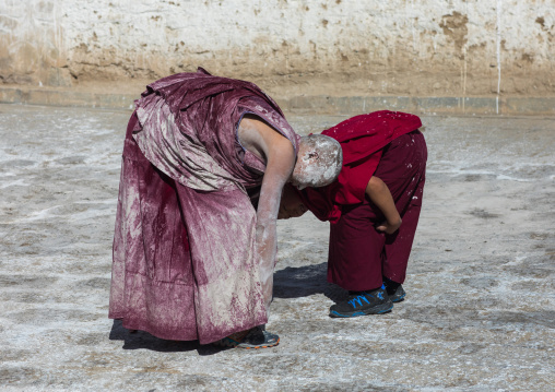 Tibetan monks enjoying a water fight after the yearly renovation of the Rongwo monastery, Tongren County, Longwu, China