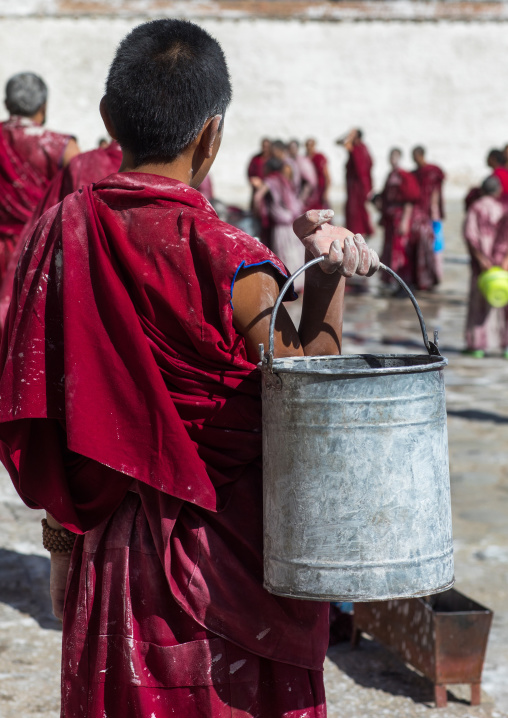 Tibetan monks enjoying a water fight after the yearly renovation of the Rongwo monastery, Tongren County, Longwu, China