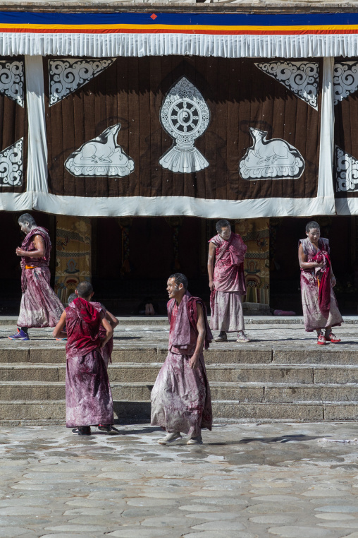 Tibetan monks enjoying a water fight after the yearly renovation of the Rongwo monastery, Tongren County, Longwu, China