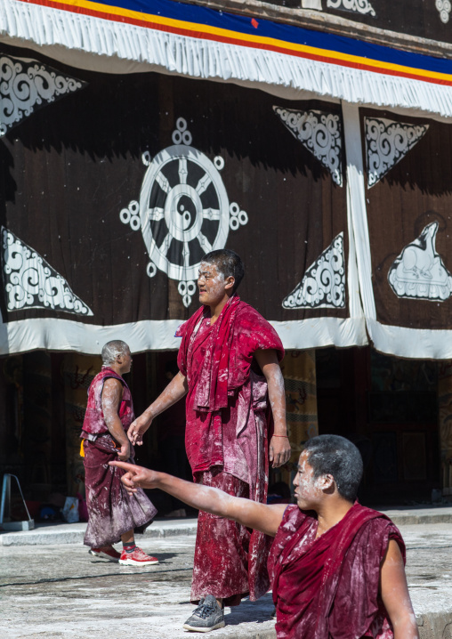 Tibetan monks enjoying a water fight after the yearly renovation of the Rongwo monastery, Tongren County, Longwu, China