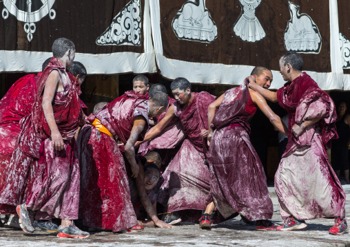 Tibetan monks enjoying a water fight after the yearly renovation of the Rongwo monastery, Tongren County, Longwu, China