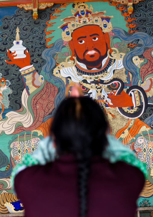 Tibetan woman praying in Rongwo monastery, Tongren County, Longwu, China