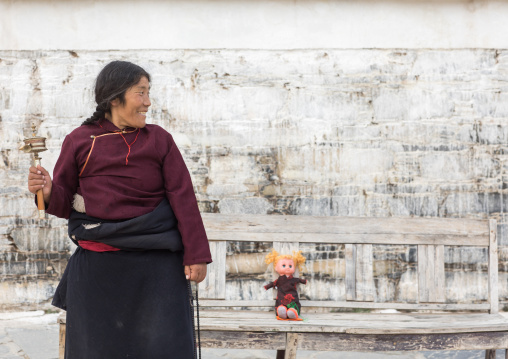 Tibetan nomad woman holding a prayer wheel in her hand, Gansu province, Labrang, China