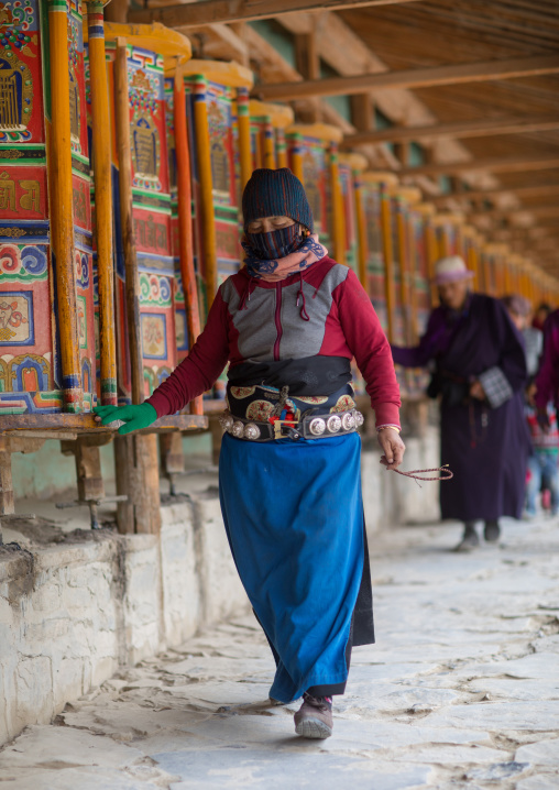 Tibetan pilgrims turning huge prayer wheels in Labrang monastery, Gansu province, Labrang, China