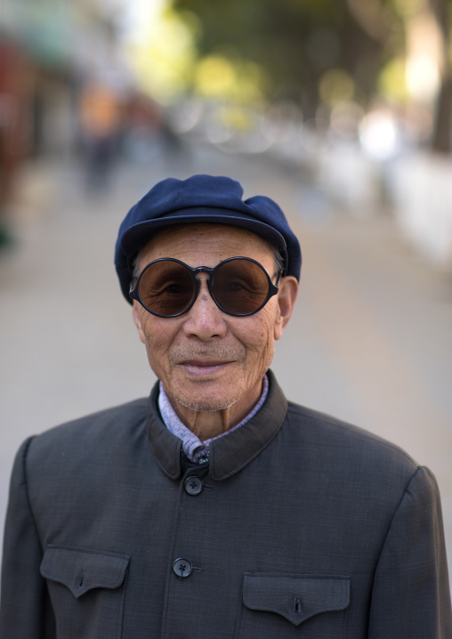 Old man with traditional sunglasses and cap, Gansu province, Linxia, China