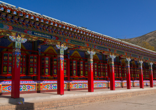 Beautifully painted and adorned prayer wheels in Wutun si monastery, Qinghai province, Wutun, China