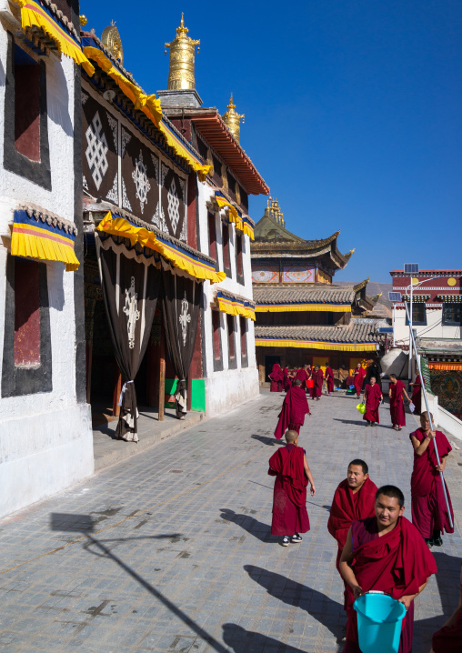 Monks carrying buckets for the painting of a temple in Rongwo monastery, Tongren County, Longwu, China