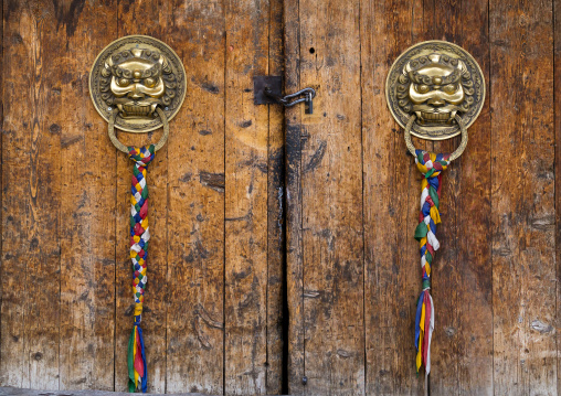 Ornate knockers on traditional buddhist door temple in Rongwo monastery, Tongren County, Longwu, China