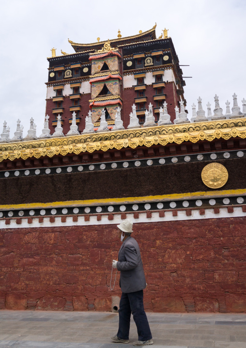 Tibetan pilgrim doing kora around Hezuo monastery and its milarepa tower, Gansu province, Hezuo, China