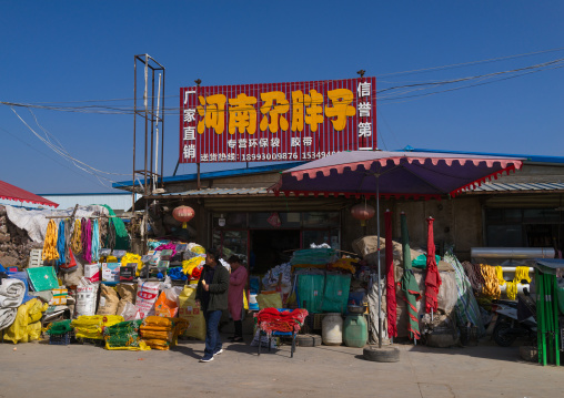 Bundles of nylon heavy-duty commercial quality rope and bags are displayed outside a shop for sell, Gansu province, Linxia, China