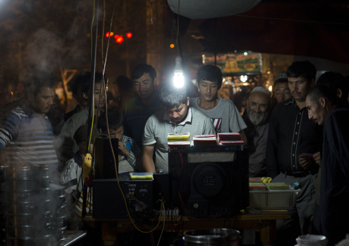 Man Selling Dvd In Night Market, Hotan, Xinjiang Uyghur Autonomous Region, China