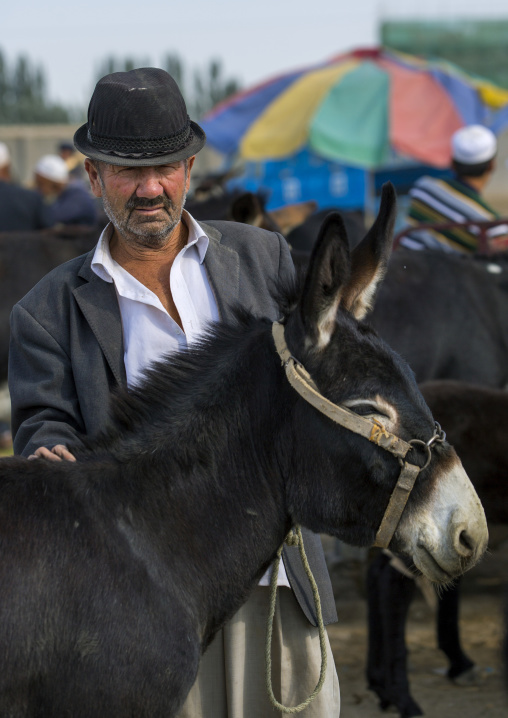 Uyghur Man Holding A Donkey In Serik Buya Market, Yarkand, Xinjiang Uyghur Autonomous Region, China