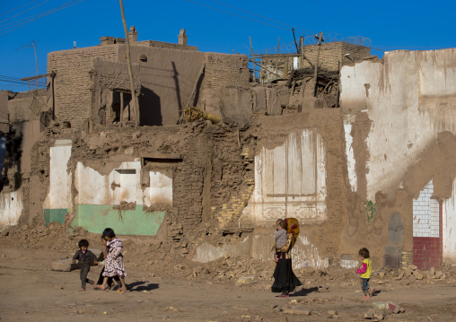 family passing in the Demolished Old Town Of Kashgar, Xinjiang Uyghur Autonomous Region, China