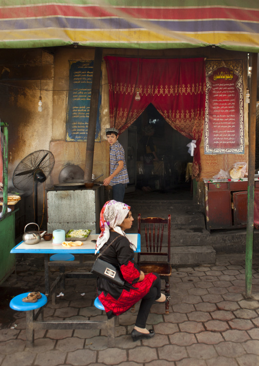 Young Uyghur Woman Waiting At The Table Of A Restaurant, And Cook, Keriya, Old Town, Xinjiang Uyghur Autonomous Region, China